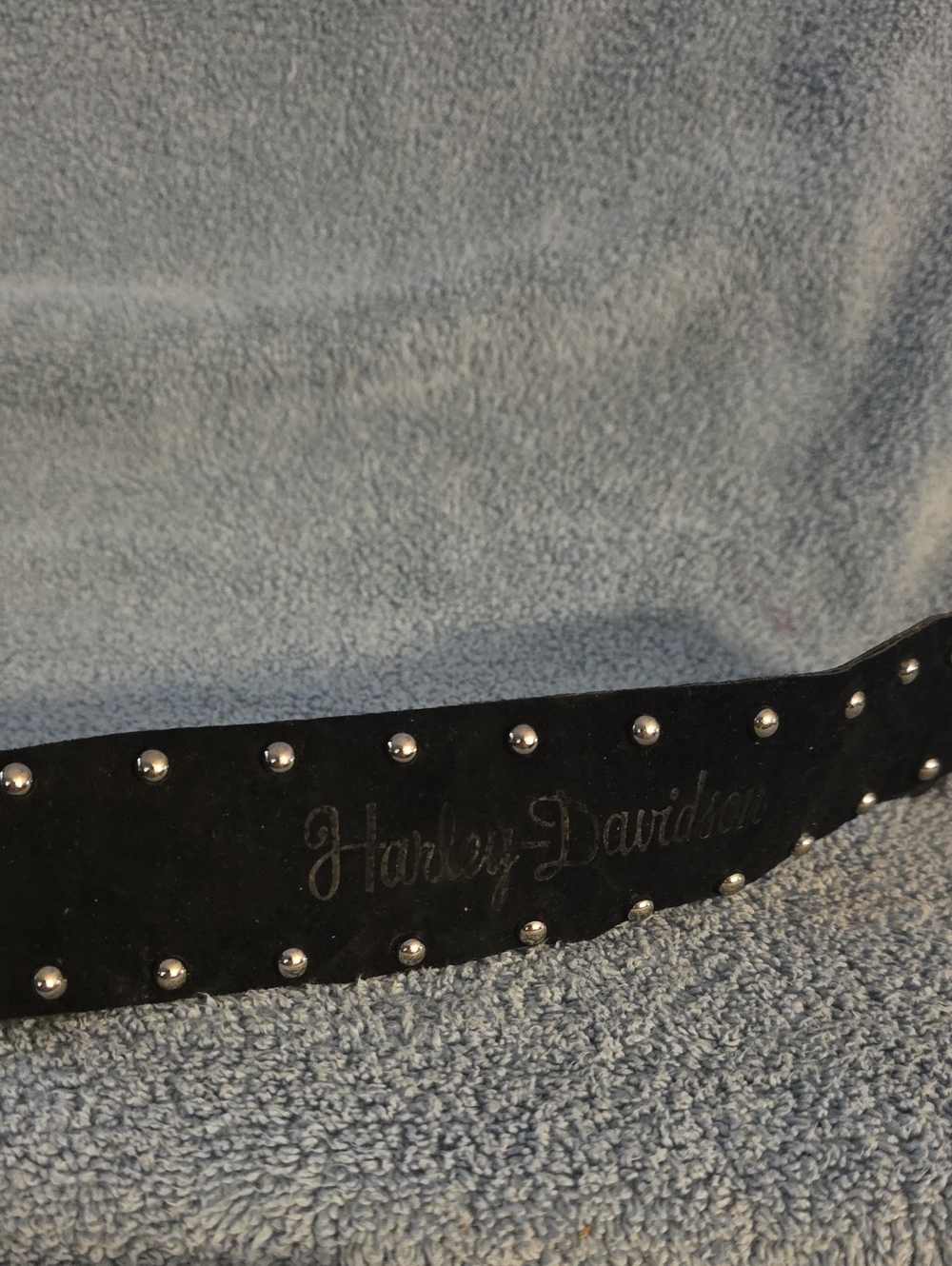 black Harley-Davidson leather belt decorated with silver studs and a cursive scr